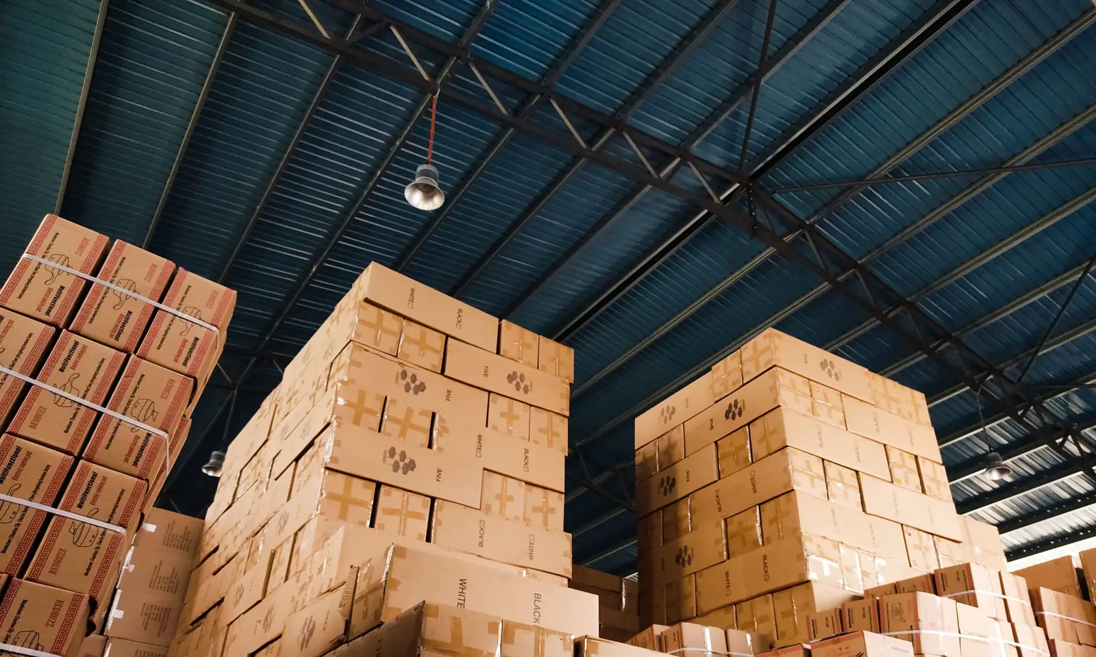 Tall stacks of wholesale product cartons in a supplier warehouse